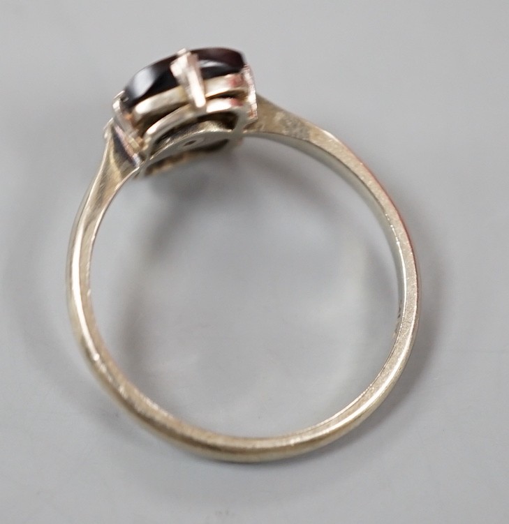 A 9ct white metal, black onyx and single stone diamond set tablet ring, size O, gross weight 2.1 grams.